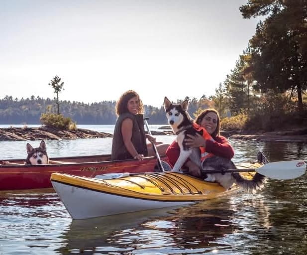 Nour et Hoda en canoë avec leurs chiens sur un lac